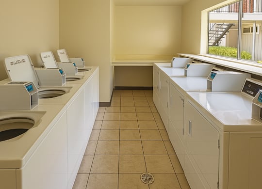 A row of automatic touchless hand dryers are lined up on a counter.