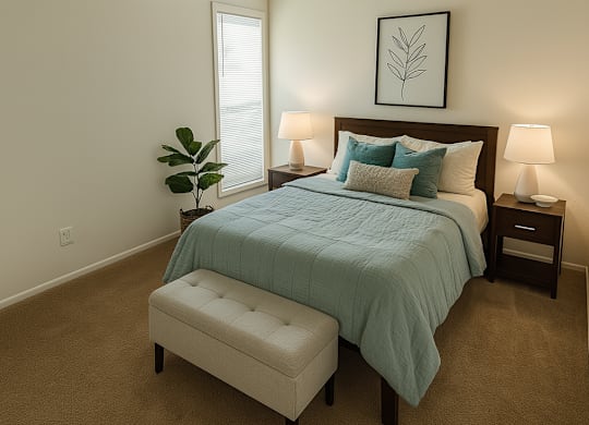 A bedroom with a bed, nightstands, and a plant.