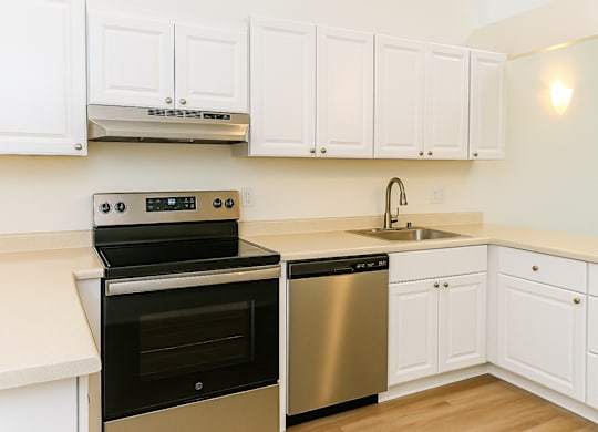 A kitchen with white cabinets and a black oven.at Hamilton Woods, Novato