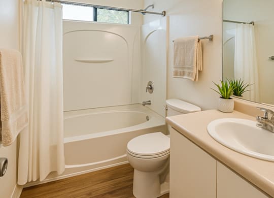 A white bathroom with a toilet, sink, and bathtub.at Hamilton Woods, Novato