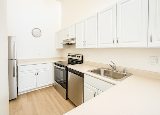 A kitchen with white cabinets and a black dishwasher.at Hamilton Woods, Novato California