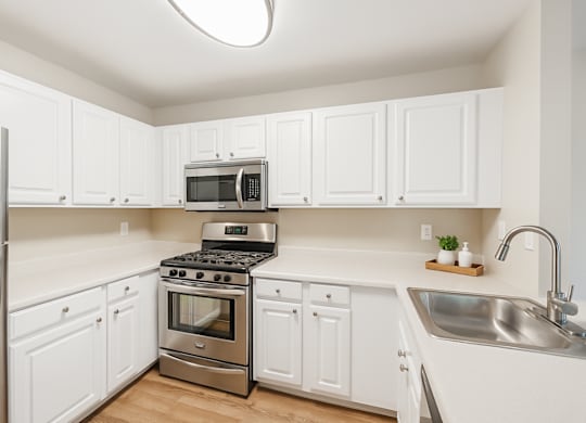 A kitchen with white cabinets and stainless steel appliances.