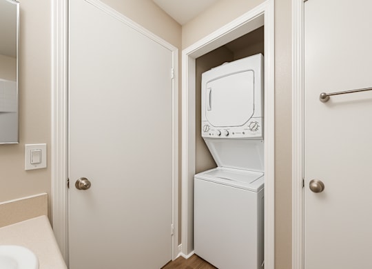 A white refrigerator is in a small bathroom.