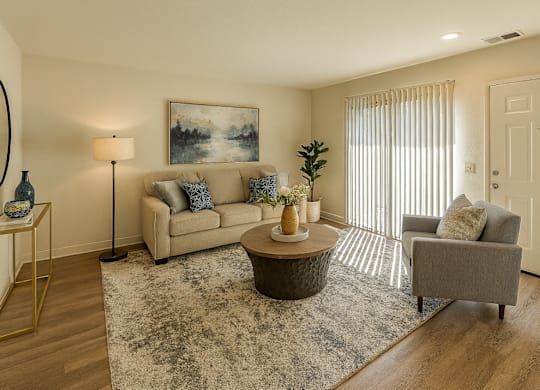A living room with a couch, a coffee table, and a painting on the wall.
