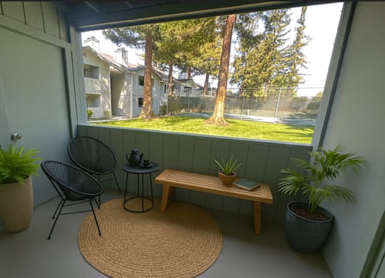 A balcony with a chair, table, and potted plants.