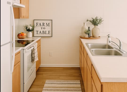 A kitchen with a white fridge and a farm to table sign on the wall.