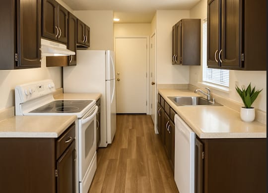 A kitchen with white appliances and brown cabinets.