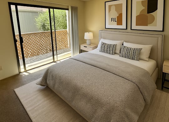 A bedroom with a large bed and two framed pictures on the wall.