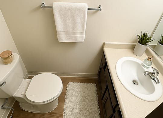 A white towel hangs on a towel rack in a bathroom.