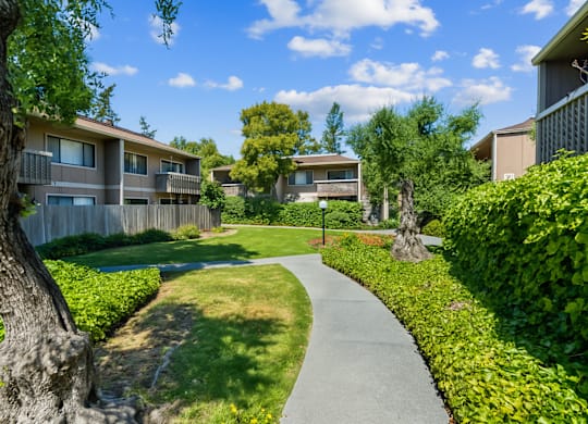 A residential area with apartment buildings and a well-maintained lawn.