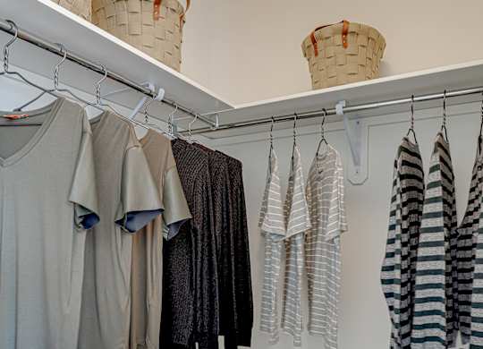 Clothes hanging on a rack in a room.