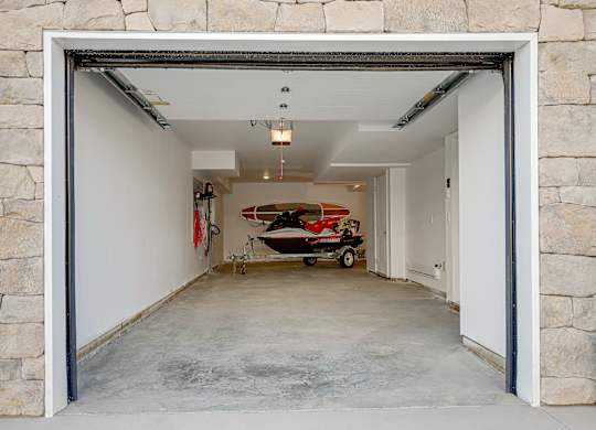 A garage with a red and white boat inside.