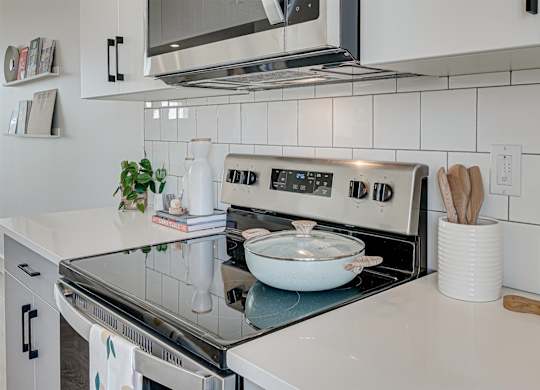 A modern kitchen with a stove top oven and a microwave above it.