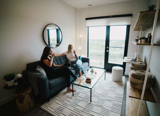 two women sitting on a couch in a living room