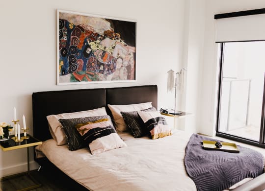 a bedroom with a bed and a painting on the wall