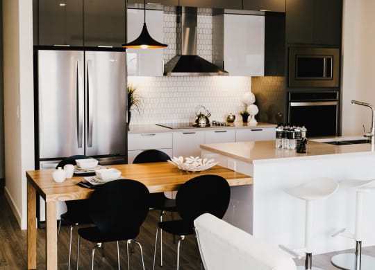a kitchen and dining area with black and white appliances and a wooden table
