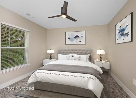A bedroom with a large bed and a ceiling fan.