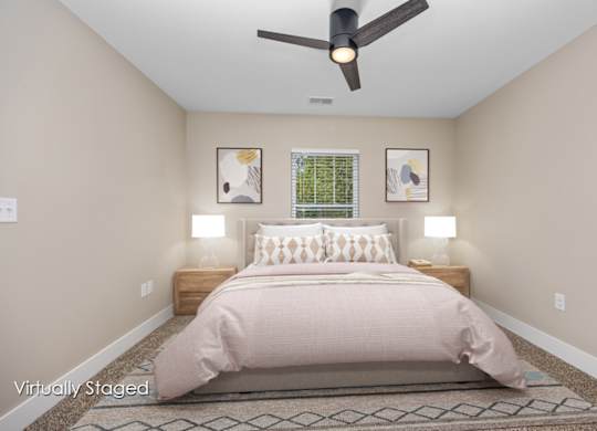 A bedroom with a bed, two lamps, and a ceiling fan.