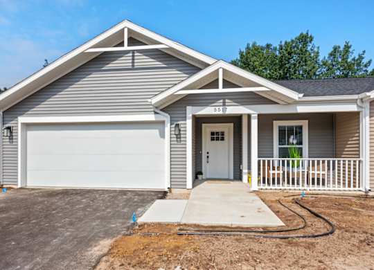 A two-story house with a garage and a driveway.