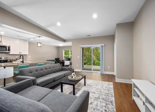 A modern living room with grey couches and a coffee table.