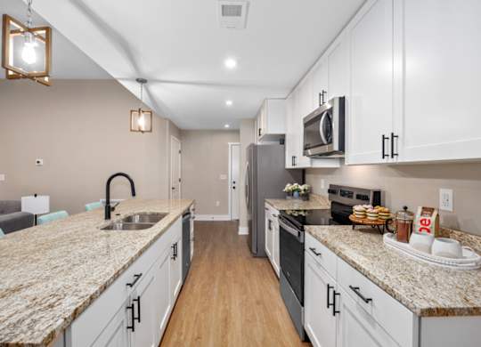 A kitchen with granite countertops and stainless steel appliances.