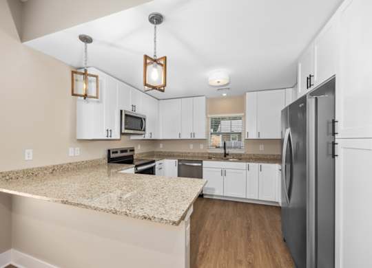 A kitchen with a granite countertop and a refrigerator.