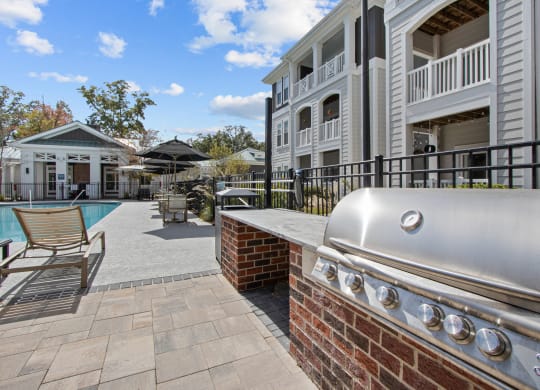 a barbecue grill on a brick wall next to a pool