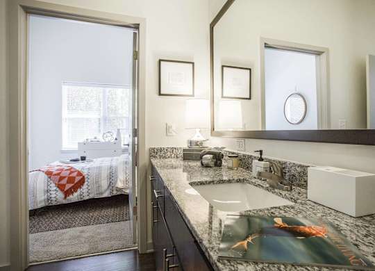 A bathroom with a sink, mirror, and a window.