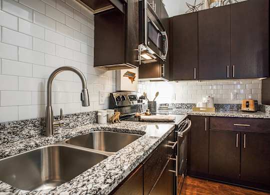A kitchen with a sink and a microwave.