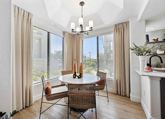 A dining room with a round table and chairs.