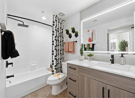 A bathroom with a toilet, sink, and shower.