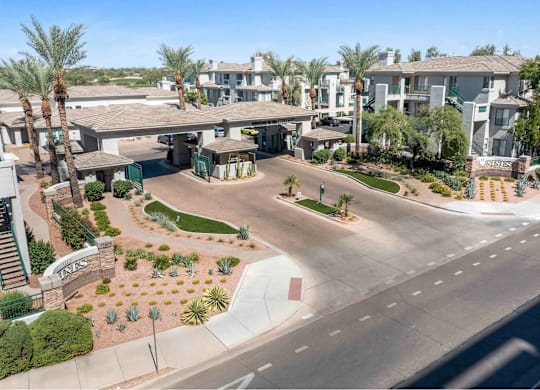 A sunny day at a residential complex with palm trees and a clear blue sky.