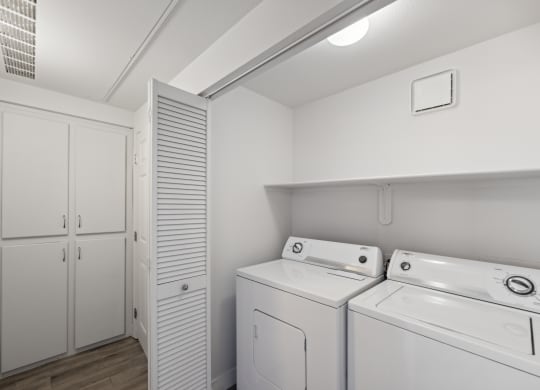 a white laundry room with white appliances and a white closet