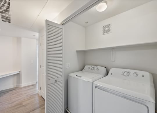a white laundry room with two washes and a dryer in it