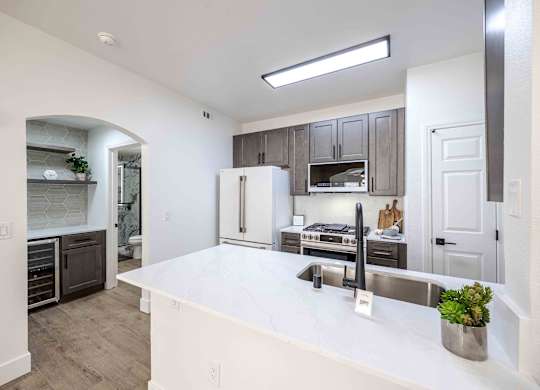a kitchen with a large white counter top and a sink