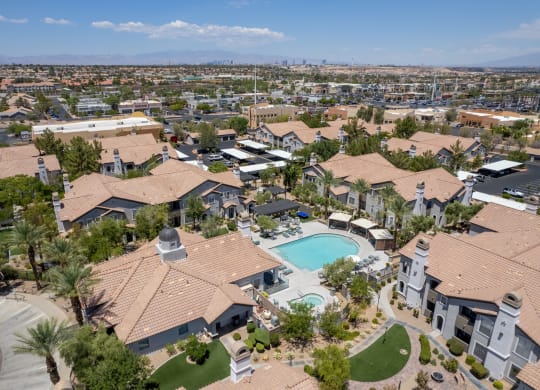A large, luxurious house with a pool in the middle of a neighborhood.