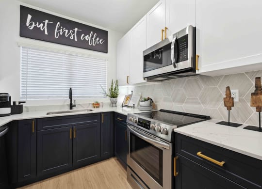 a kitchen with white countertops and black cabinets