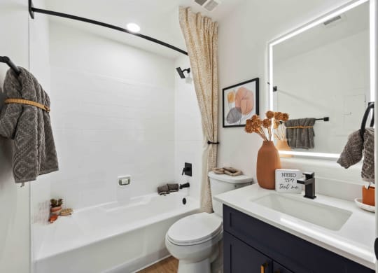 a bathroom with a white tub next to a toilet and a sink