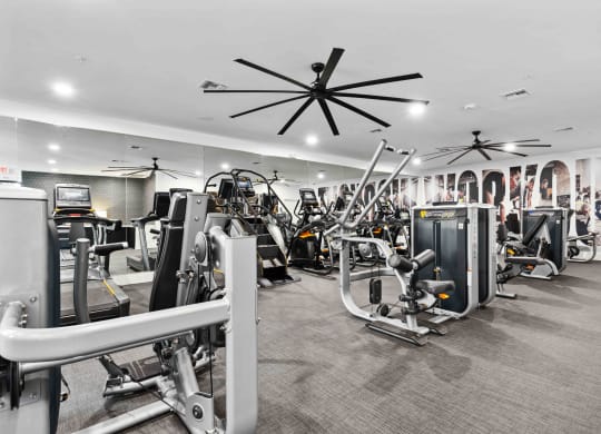 a large fitness room with cardio machines and other exercise equipment