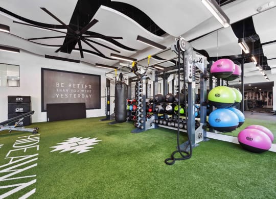 a spacious fitness room with green carpet at hideaway apartments