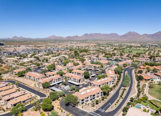 an aerial view of north scottsdale with houses and trees and mountains in the background