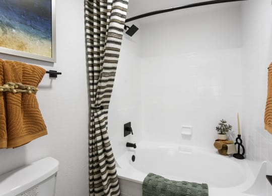 a white bathroom with a tub and a shower curtain
