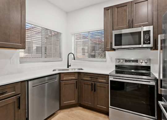 A kitchen with brown cabinets and stainless steel appliances.