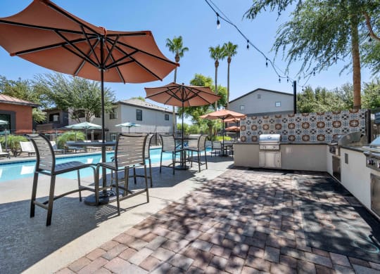 bbq grill area near swimming pool at lazo apartments in chandler, az