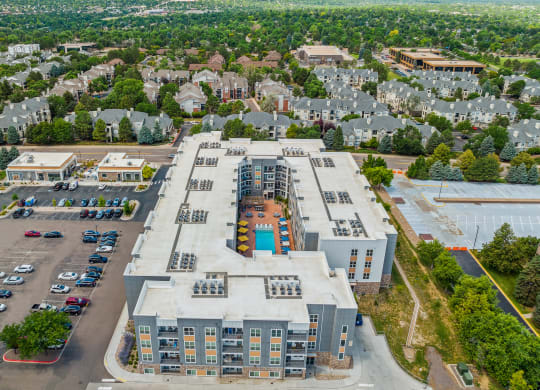 an aerial view of a large apartment complex with trees in the background