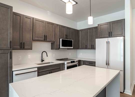 a kitchen with a white counter top and a refrigerator