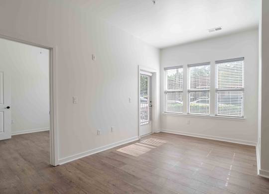 an empty living room with white walls and wood floors