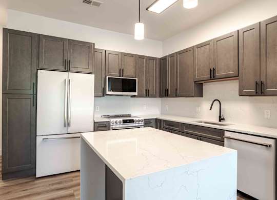 a kitchen with a large island and stainless steel appliances
