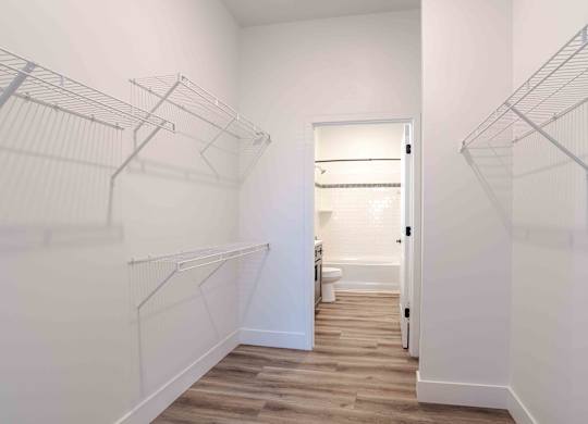 an oversized closet with white walls and wood floors