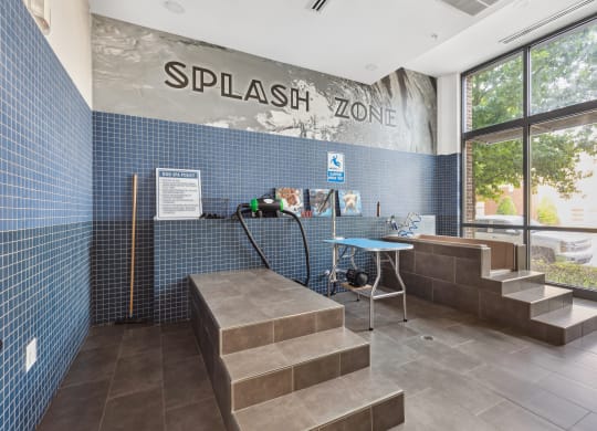 the entrance to thesplash zone with a bench and a table with a water hose
